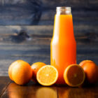 Sortiment Saefte mit Flasche Orangensaft und Orangen um die Flasche