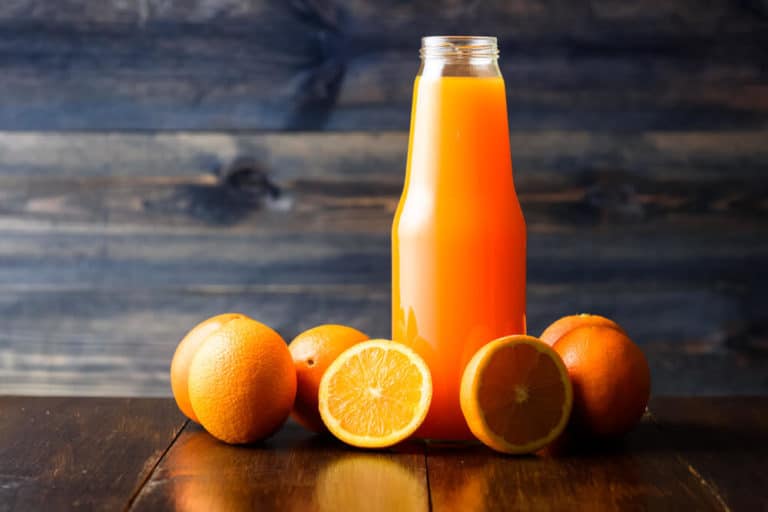 Sortiment Saefte mit Flasche Orangensaft und Orangen um die Flasche